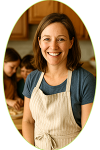 Rachel Moore smiling in her kitchen, wearing an apron with her children in the background